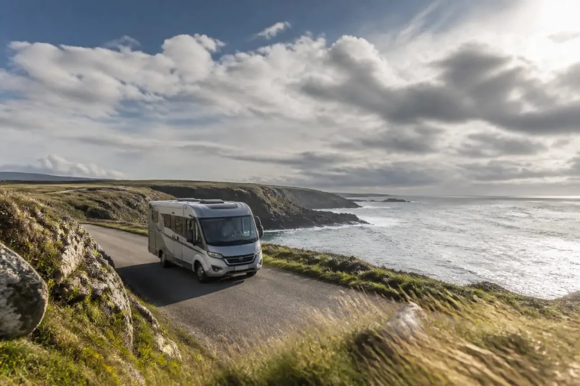 Visite Bretagne en camping car sur une route côtière bretonne avec vue sur la mer
