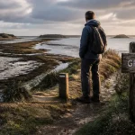GR34 Golfe du Morbihan : marcheur sur sentier côtier près de balise