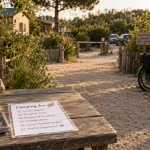 Camping écologique morbihan : allée en sable, vélos et cabanes en bois